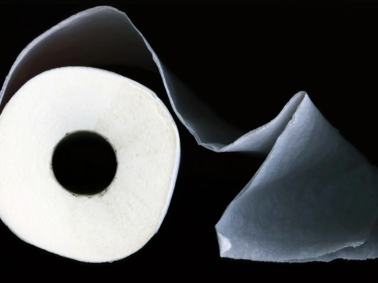 In the front of the image there is a tissue roll. In the background of the image is dark.