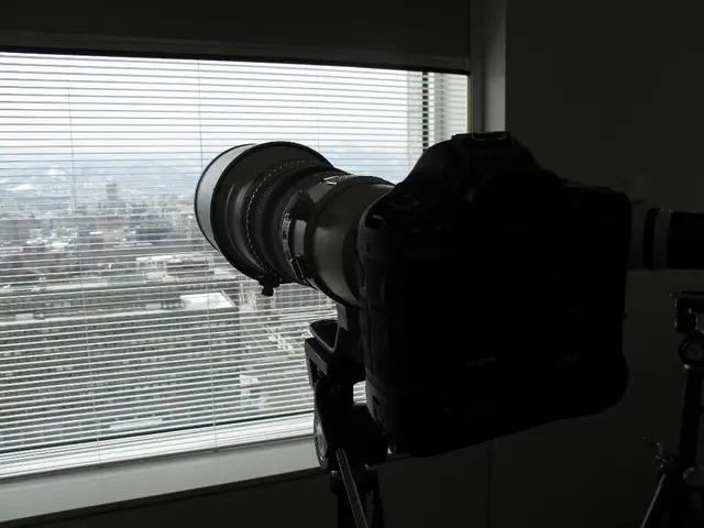 In this picture there is a camera in the center of the image in front of a window and there are...