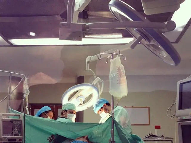 The picture is taken in an operation theater. In the center of the picture we can see a surgery...