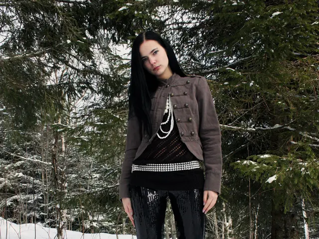 In this image there is a girl standing on the snow. Behind her there are so many trees. At the...