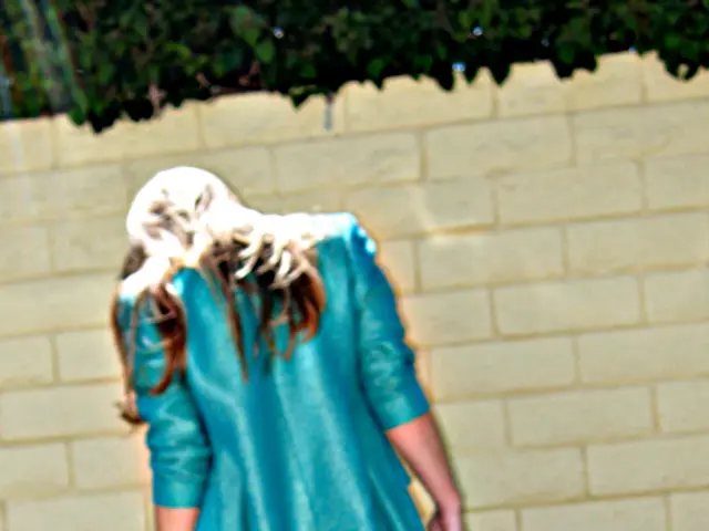 This picture is clicked outside. In the center there is a person wearing blue color jacket, holding...